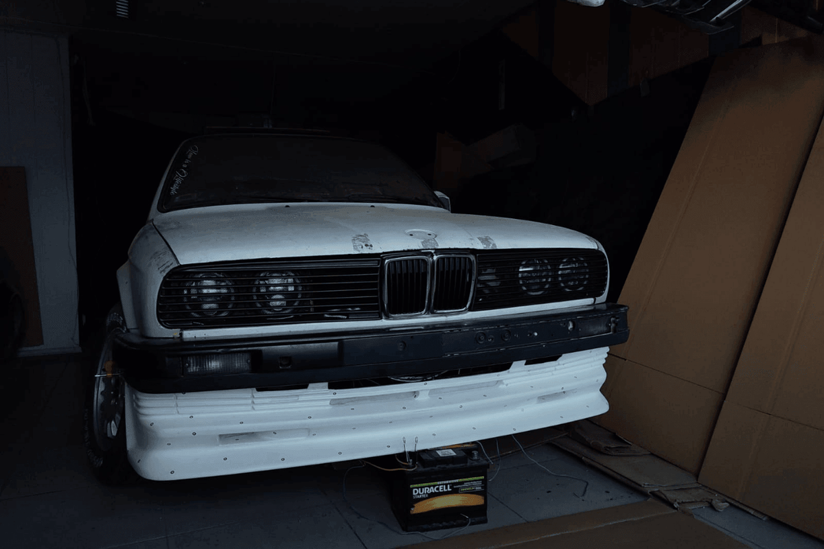 BMW E30 Series 3 headlight set with steady style front grille by K2 Industries, featuring clear headlights and black grille details.