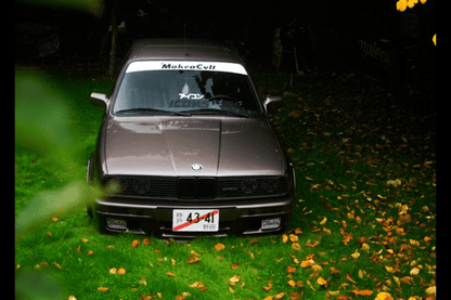 BMW E30 Series 3 headlights and front grille by K2 Industries, vintage car front view with headlights and grille visible.