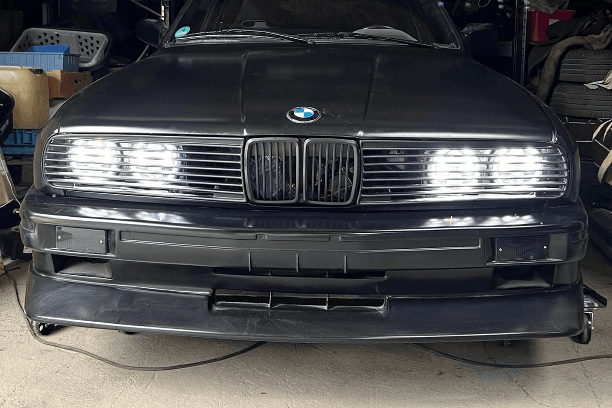 BMW E30 Series 3 front grille and headlights by K2 Industries, showing the sleek headlight design and grille details for 1984-1991.