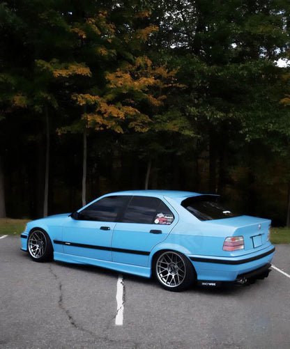 Black BMW E36 Sedan Series 3 HM Style roof spoiler by K2 Industries, mounted on the car's roof for sporty look.