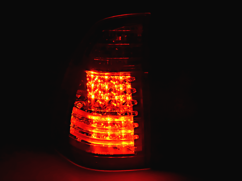 BMW X5 E53 black and clear LED tail lights by K2 Industries, compatible with 1998-2002 models, showing close-up of illuminated lights.