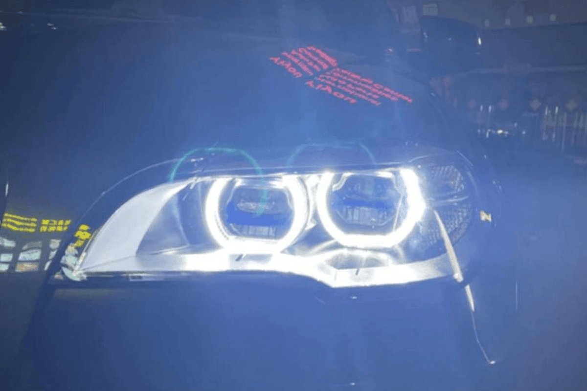 BMW X5 E70 OE Style Angel Eyes projector headlight by K2 Industries, showing the sleek design and bright lighting elements.