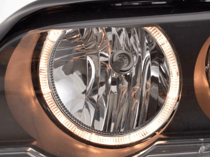 Black OE+ Angel Eyes headlights for BMW X5 E53 (2000-2003) by K2 Industries, showcasing the sleek design and angel eye accents.