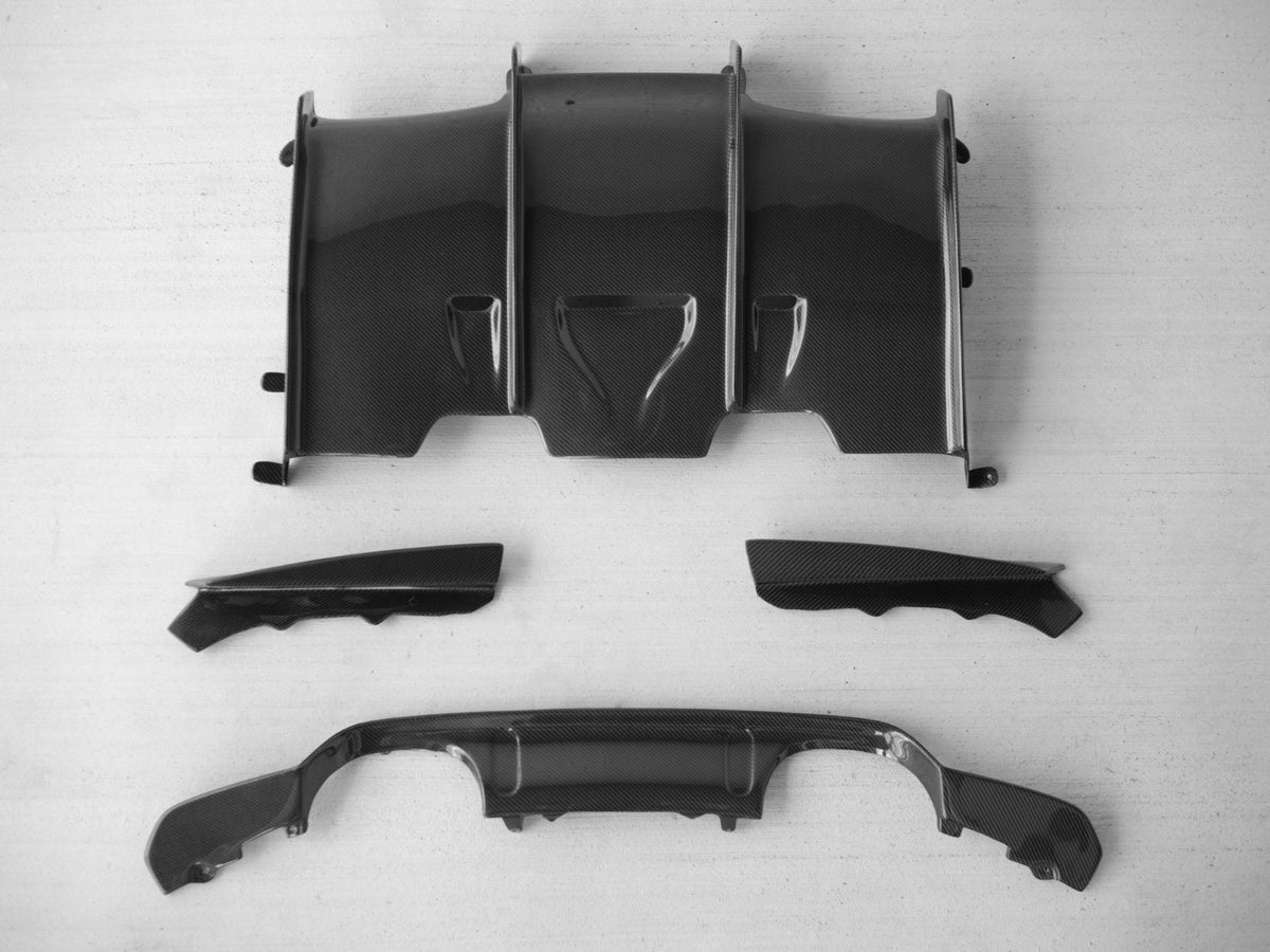BMW F80 M3 and F82/F83 M4 carbon fiber rear diffuser by Palenon Performance, showing sleek, aerodynamic design and textured carbon fiber finish.