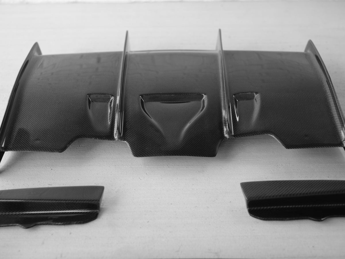 BMW F80 M3 and F82/F83 M4 carbon fiber rear diffuser by Palenon Performance, showcasing sleek aerodynamic design.