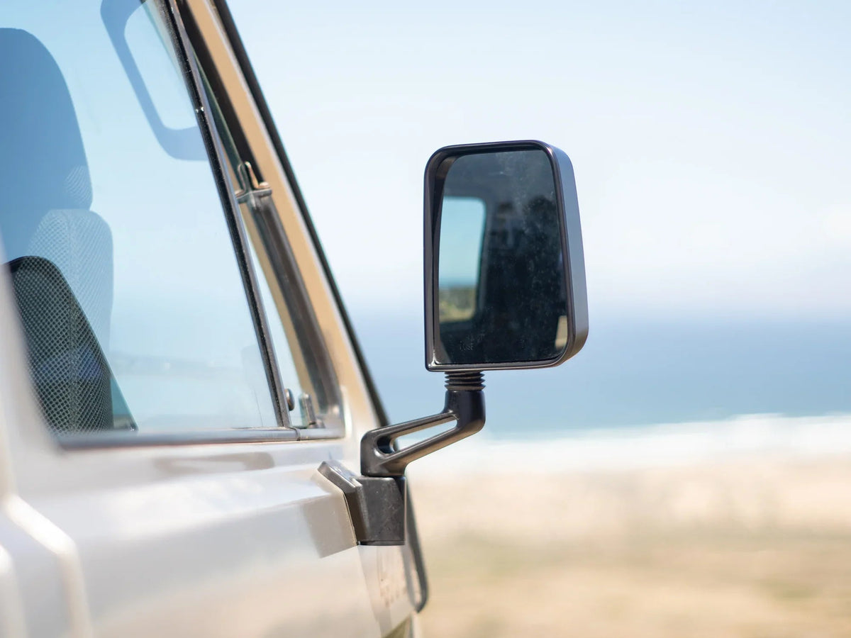 GoWesty Deluxe Manual Mirror Kit for Vanagon showing assembled mirrors with black frames and mounting hardware.
