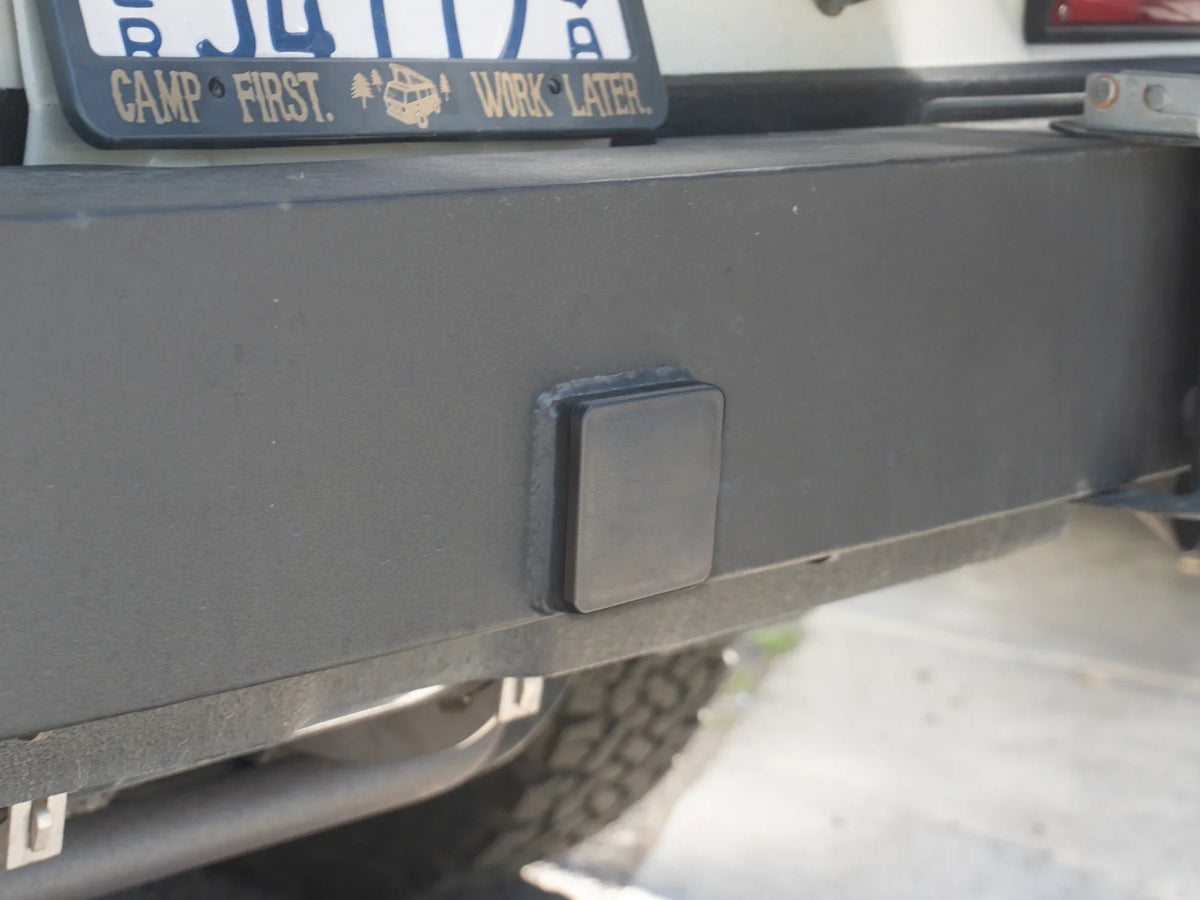 Black square snap-in hitch hole cap by GoWesty, designed to cover and protect trailer hitch openings.