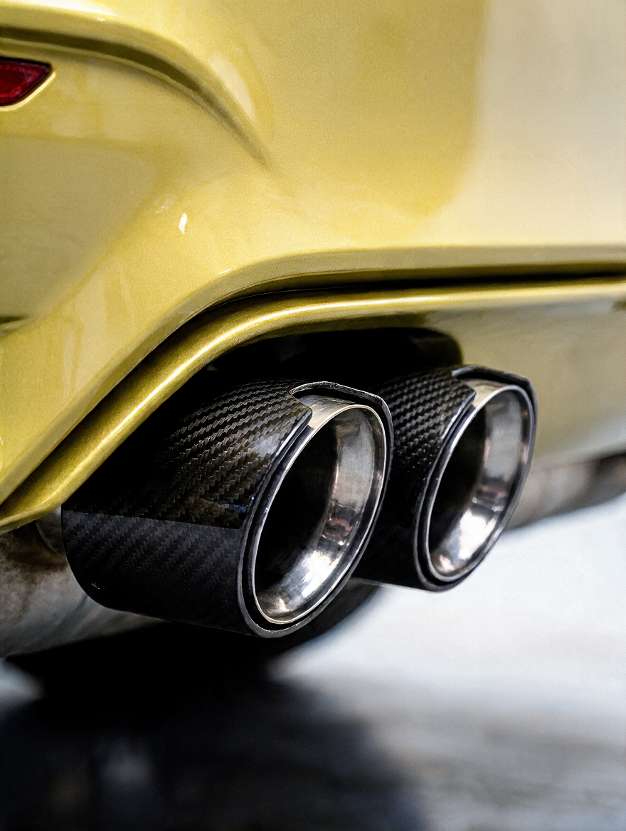 BMW universal fit carbon fiber muffler tips by K2 Industries, showing sleek black carbon fiber with polished metal tips.
