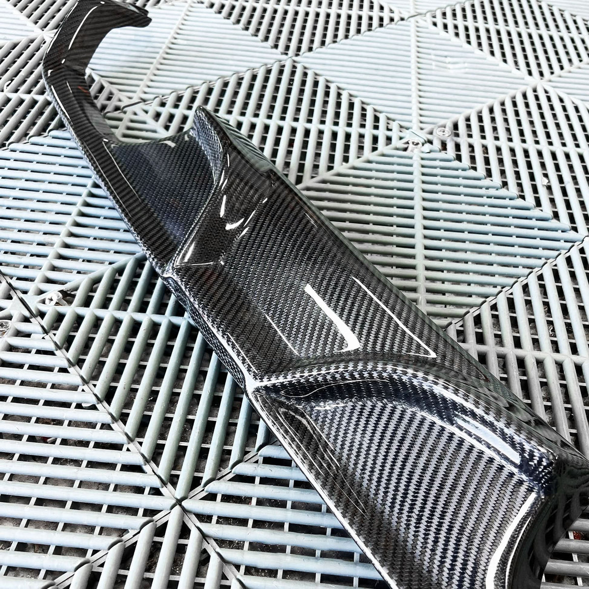 BMW 3/4 Series F80/F82/F83 carbon fiber diffuser by K2 Industries, showcasing sleek design and textured carbon fiber surface.