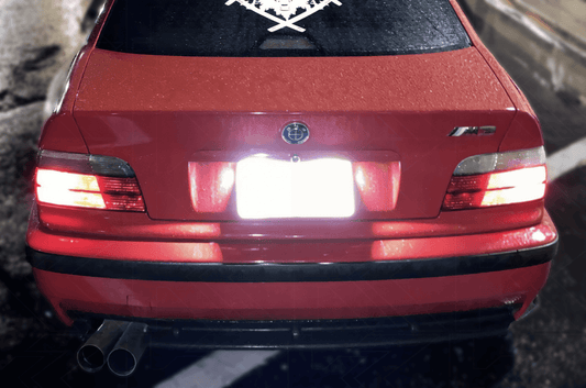 K2 Industries LED license plate lights for BMW E36 1992-1999, super bright bulbs installed on a vehicle's license plate area.