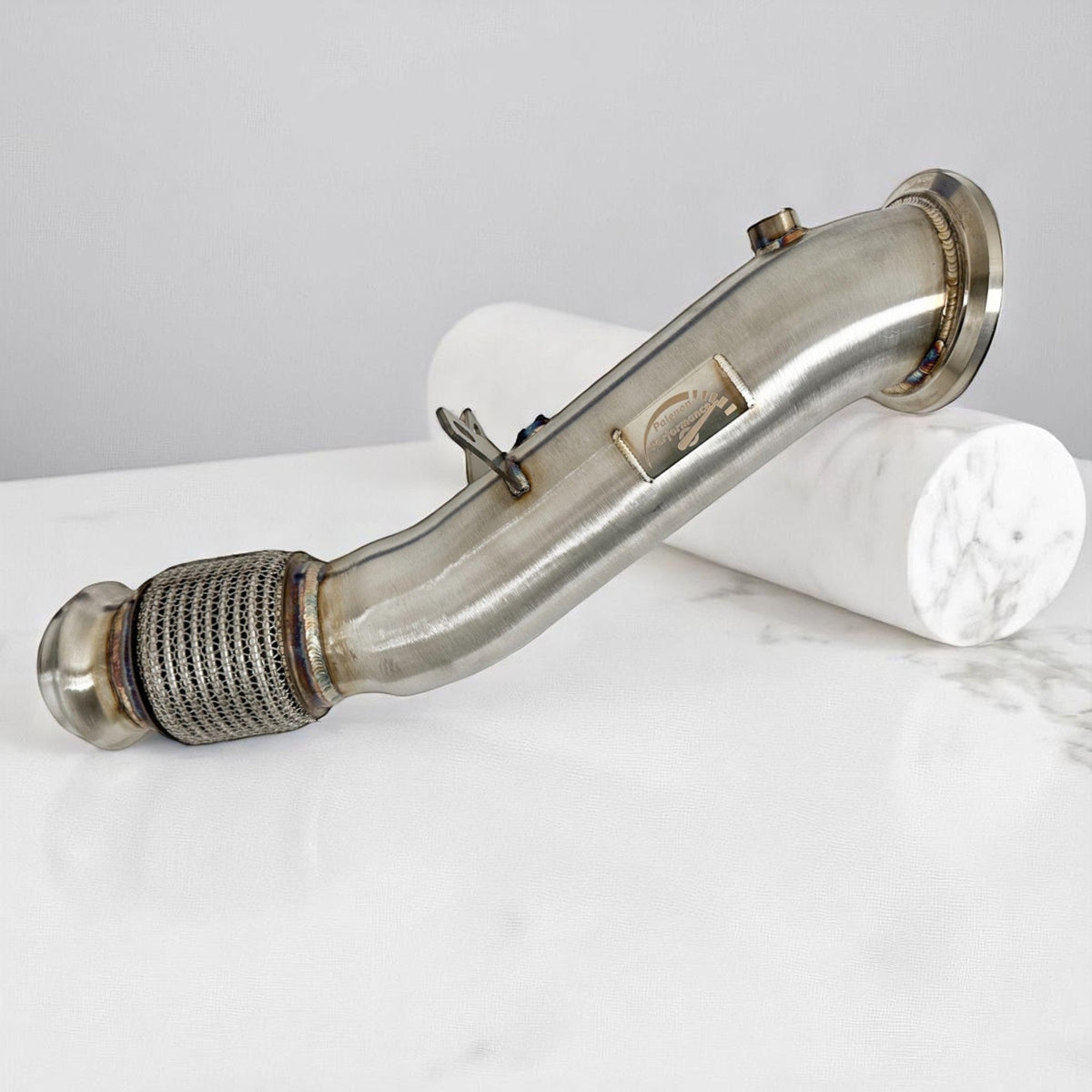 Palenon Performance B46 B48 Racing Downpipe for BMW and Toyota Supra, showing the polished metal pipe with mounting flanges.