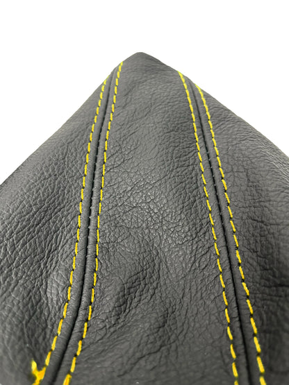 Black genuine leather shift and handbrake boot cover with yellow stitching for BMW E91, E92, E93 models by JTS Custom Upholstery.